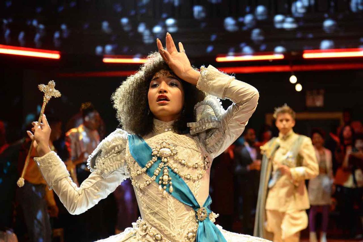 Indya Moore as Angel in a white dress from a ballroom scene from FX series Pose.