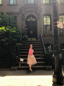 a woman sitting on a bench in front of a building