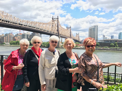 a group of people standing in front of a bridge